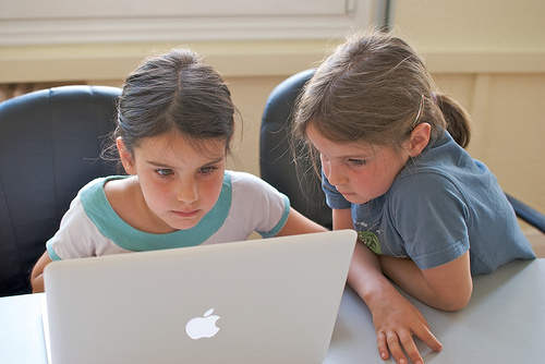 photo: two girls working together on a Mac